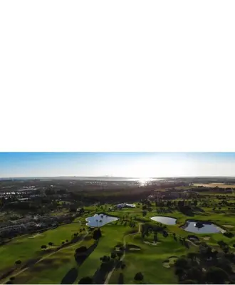 an aerial view of a golf course with two ponds at Villa Nostra in Puerto Real