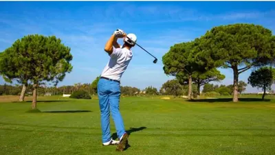 a man swinging a golf club on a golf course at Villa Nostra in Puerto Real