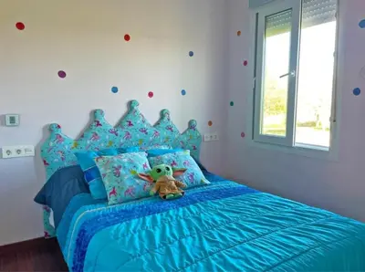 a bedroom with a blue bed with a teddy bear on it at Villa Nostra in Puerto Real