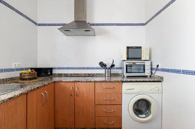 a kitchen with a washing machine and a microwave at Bellavista De Conil in Conil de la Frontera