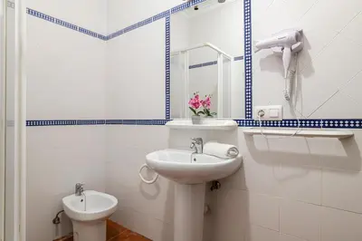 a white bathroom with a sink and a toilet at Bellavista De Conil in Conil de la Frontera