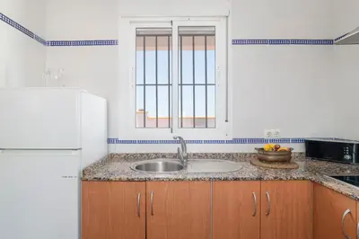 a kitchen with a sink and a white refrigerator at Bellavista De Conil in Conil de la Frontera