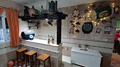a kitchen with a stove and a counter with stools at Villa Mi Deseo in Sanlúcar de Barrameda