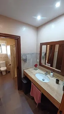 a bathroom with a sink and a mirror and a toilet at Villa Mi Deseo in Sanlúcar de Barrameda