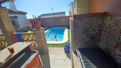 a swimming pool in a backyard with a person in the water at Villa Mi Deseo in Sanlúcar de Barrameda