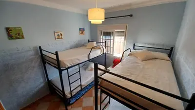 two bunk beds in a room with a window at Villa Mi Deseo in Sanlúcar de Barrameda