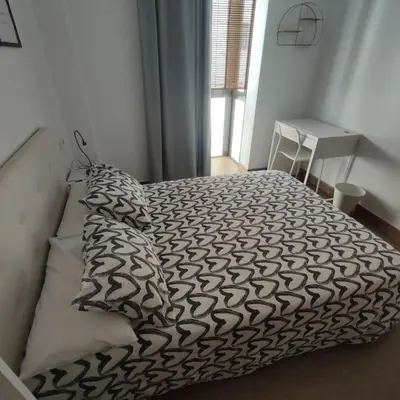 a bed with black and white sheets and pillows at Medina-Sidonia. Apartamento. Carrión y La Zaga in Medina Sidonia