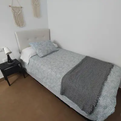 a bedroom with a bed with a black and white blanket at Medina-Sidonia. Apartamento. Carrión y La Zaga in Medina Sidonia