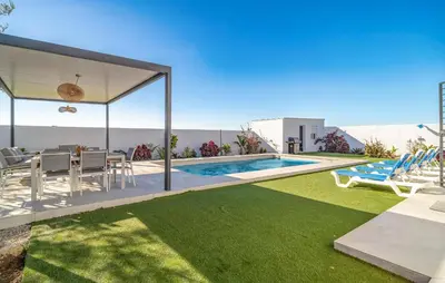 a villa with a swimming pool and a table and chairs at Gorgeous Home In Chiclana De La Fronter in Chiclana de la Frontera