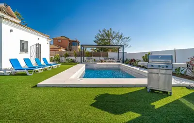 a backyard with a grill and a swimming pool at Gorgeous Home In Chiclana De La Fronter in Chiclana de la Frontera