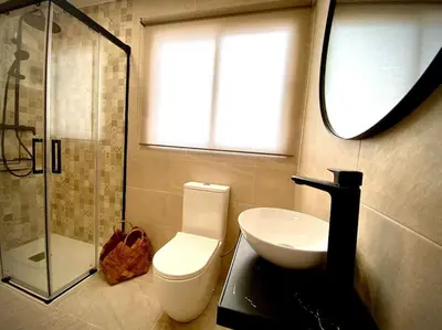 a bathroom with a toilet and a sink and a window at MyChoice Salmarina in Rota