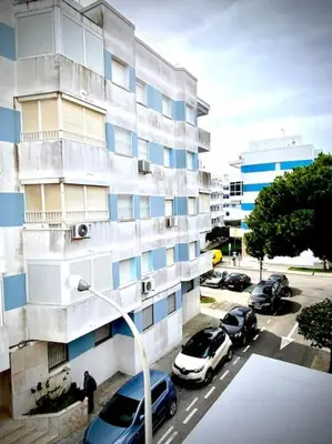 a building with cars parked in a parking lot at MyChoice Salmarina in Rota