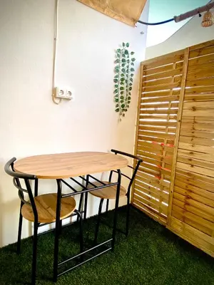 a wooden table and two chairs next to a wall at MyChoice Salmarina in Rota