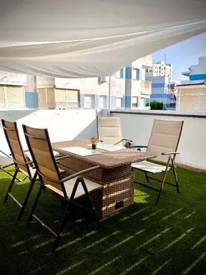 a table and chairs under a white canopy on a roof at MyChoice Salmarina in Rota
