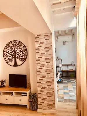 a living room with a tv and a tree on the wall at Disfruta, nuevo en Mentidero in Cádiz