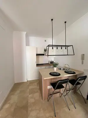 a kitchen with a table with two chairs and a sink at La Marchena in Jerez de la Frontera