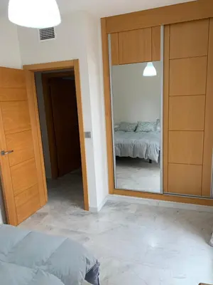 a bedroom with a mirror and a bed in a room at Habitacion privada en piso compartido de dos habitaciones en urbanización con piscina y pista de padel in El Puerto de Santa María