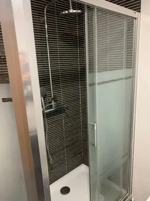 a shower with a glass door in a bathroom at Habitacion privada en piso compartido de dos habitaciones en urbanización con piscina y pista de padel in El Puerto de Santa María
