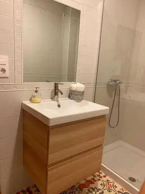 a bathroom with a sink with a mirror and a shower at Villa Estrella in Jerez de la Frontera