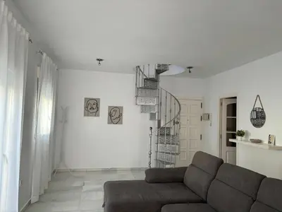 a living room with a couch and a spiral staircase at Ocón 2 in Lebrija