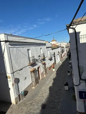 an alley with white buildings and a blue sky at Ocón 2 in Lebrija