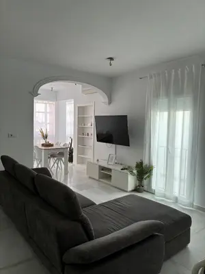 a white living room with a couch and a table at Ocón 2 in Lebrija