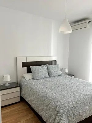 a bedroom with a bed and two nightstands and two lamps at Ocón 2 in Lebrija