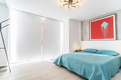 a bedroom with a bed with a drawing on the wall at Secreto de Lola in El Puerto de Santa María