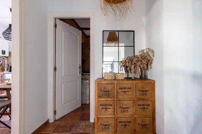 a hallway with a door and a dresser with flowers on it at Chalet playa la Barrosa, Chiclana in Chiclana de la Frontera