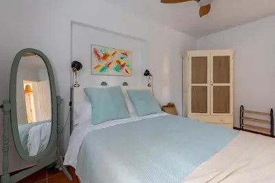 a bedroom with a large bed and a mirror at Chalet playa la Barrosa, Chiclana in Chiclana de la Frontera