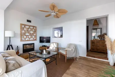a living room with white furniture and a ceiling fan at Chalet playa la Barrosa, Chiclana in Chiclana de la Frontera