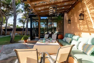 a patio with a couch and a table and chairs at Chalet playa la Barrosa, Chiclana in Chiclana de la Frontera