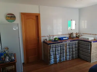 a kitchen with a counter with a sink and a door at Albanta in Chipiona