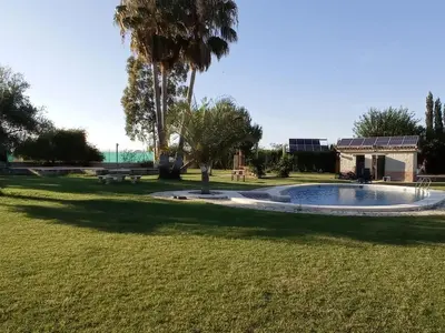 a swimming pool in a park with a picnic table at Albanta in Chipiona
