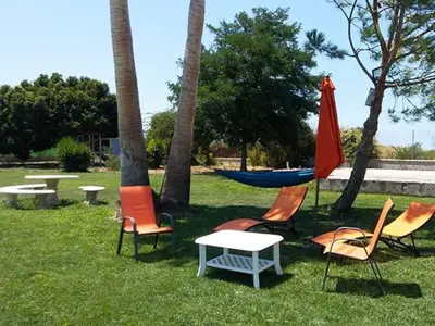 a group of chairs and a hammock in a park at Albanta in Chipiona