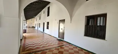 an empty hallway of a building with white walls and a tile floor at Tartaneros Duplex by Sanlúcar Housing in Sanlúcar de Barrameda
