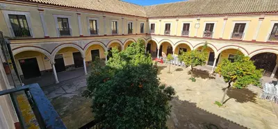 an empty courtyard with trees in front of a building at Tartaneros Duplex by Sanlúcar Housing in Sanlúcar de Barrameda