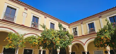 a building with orange trees in front of it at Tartaneros Duplex by Sanlúcar Housing in Sanlúcar de Barrameda