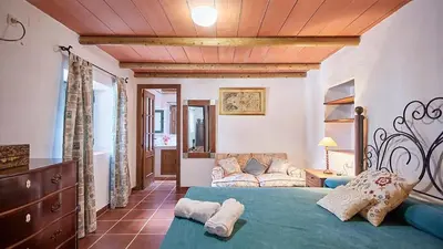 a bedroom with a bed and a couch in a room at El Membrillo casa rural in Arcos de la Frontera