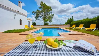 a table with a plate of fruit next to a swimming pool at El Membrillo casa rural in Arcos de la Frontera