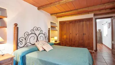a bedroom with a bed with a blue comforter at El Membrillo casa rural in Arcos de la Frontera
