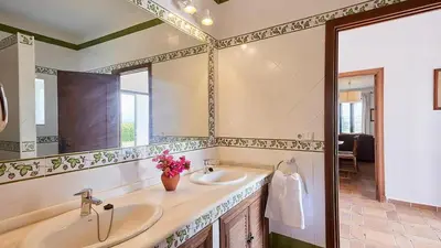 a bathroom with two sinks and a large mirror at El Membrillo casa rural in Arcos de la Frontera
