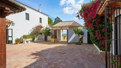 a house with flowers on the side of it at El Membrillo casa rural in Arcos de la Frontera