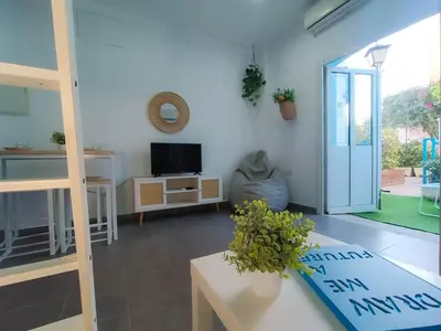 a living room with a couch and a tv at Sunset Puerto Sherry in El Puerto de Santa María