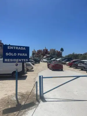 a sign in a parking lot with cars parked at Sunset Puerto Sherry in El Puerto de Santa María