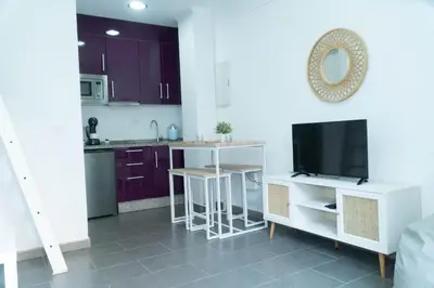 a kitchen with purple cabinets and a flat screen tv at Sunset Puerto Sherry in El Puerto de Santa María