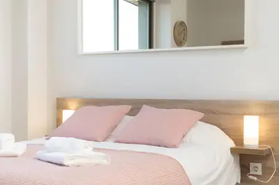 a living room with a black couch with two pink pillows at Apartoyou - Estudio Pink in El Puerto de Santa María