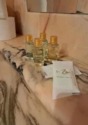 three glass bottles on a marble counter with a bag at Encanto Urbano: Piso céntrico totalmente equipado in Lebrija