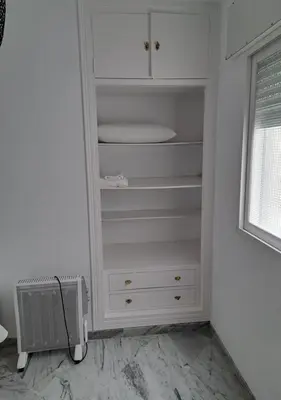 a closet with white cabinets and a window at Encanto Urbano: Piso céntrico totalmente equipado in Lebrija