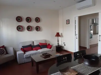 a living room with a white couch and red pillows at La Perla de Cádiz by Gades Gestión in Cádiz